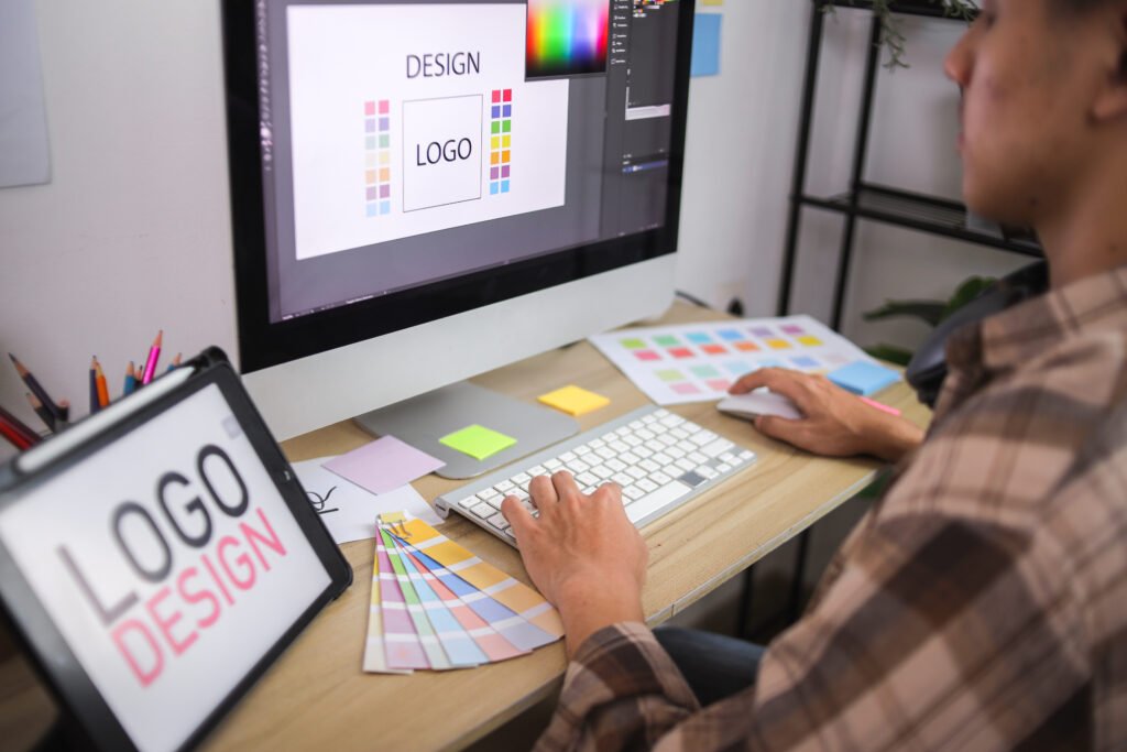 Designer graphique travaillant sur une identité visuelle de marque dans une agence de communication parisienne, création de logo et charte graphique.